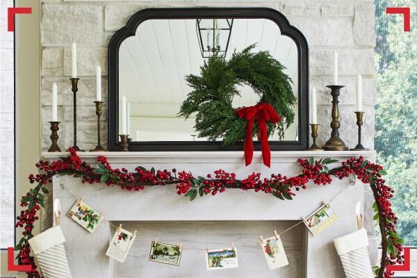 Espaço de lareira em uma casa decorada com detalhes festivos ou natalinos pendurados com Gachos Command®: guirlandas, flâmulas e flores.
